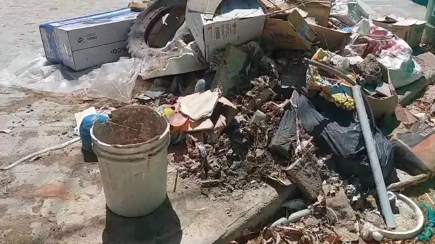 Cajas y desperdicios acumulados junto al cierre de la obra municipal.